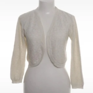 Vit bolerotopp - Säljer en stilren vit bolerotopp med trekvartsärm. Perfekt för att lägga till en elegant touch till sommaren eller varmare dagar. Den är i ny skick och har inga defekter. Jättefin att styla med ett linne eller tröja under. Pris KAN diskuteras vid SNABB affär!