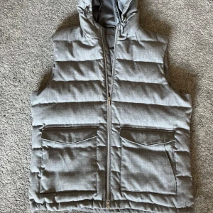 Stenströms väst - Snygg grå quiltad väst från stenströms med dragkedja och praktiska fickor framtill.  Justerbar i luva och midja. PM för Fitpic