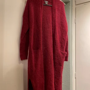 Röd lång kofta - Säljer en mysig röd lång kofta med långa ärmar. Storlek s. Fint skick. Köpt ifrån H&M 