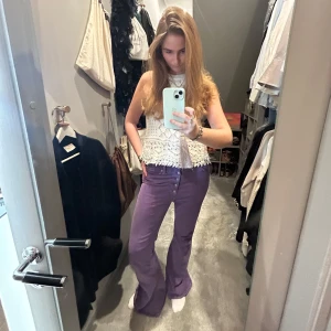 Vit virkad topp med fransdetaljer - Säljer en söt vit virkad topp med fransdetaljer i nederkant. Toppen är ärmlös och har en avslappnad passform. Perfekt för sommardagar!