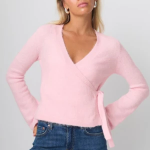 Rosa omlottopp - Säljer en söt rosa omlottopp med knytning i sidan. Toppen har långa ärmar och en v-ringad design. Säljer för att den inte kommer till andvändning. Skriv gärna för flera bilder💗