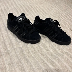Svarta Adidas Campus sneakers - Snygga svarta Adidas Campus sneakers. Använda få tal gånger därav i nästan nyskick! Svåra att få tag på i denna lilla storlek. Medföljer även original förpackning och extra snören. Nya kostar 1650kr 