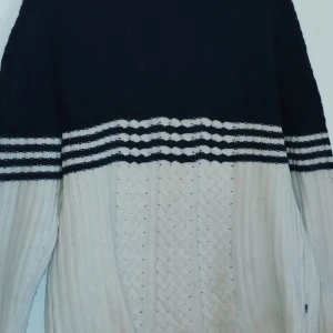 Randig stickad tröja från Lexington - Säljer en snygg stickad tröja från Lexington i svart och vit med randigt mönster. Tröjan har långa ärmar och en bekväm passform, perfekt för kyligare dagar. Den är både stilren och mysig.