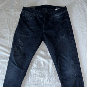 Dondup George  - Snygga mörkblå jeans med en klassisk femficksdesign. De har en lätt slitning på framsidan för en trendig look. Perfekta för en avslappnad stil. Skick9/10 knappt använda. Kontakta mig om frågor