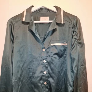Pyjamas från Abercrombie & Fitch  - Pyjamasset i siden från Abercrombie & Fitch i vacker smaragdgrön färg. Garderobsrensning så kika gärna på övriga auktioner. Ca 1100 kr i nypris.