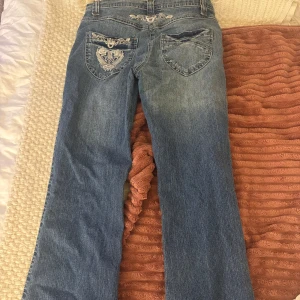 Blå lågmidjade bootcut jeans med broderi - Snygga blå jeans med broderade detaljer på bakfickorna. Lågmidjade och bootcut🥰