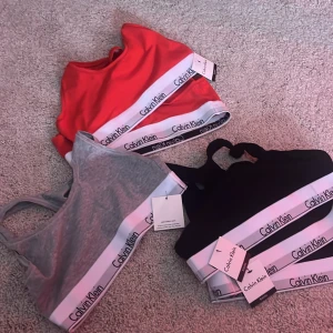 Sportiga toppar från Calvin Klein - Säljer flera sportiga toppar från Calvin Klein i olika färger: röd, svart och grå. 6 stycken olika bh:ar i olika färger. Om du vill köpa i speciell färg kan du kolla på min profil eller om du vill köpa en av varje färg kan du kontakta mig så löser vi det! Storlekar i S/M på alla. 