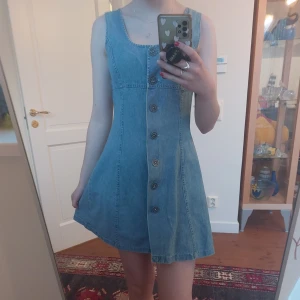 Vacker jeansklänning - Säljer en snygg jeansklänning med knappar framtill. Klänningen är ärmlös och är denimfärgad. Perfekt till sommaren! 🦋 storlek typ 36(står 40), bra skick!
