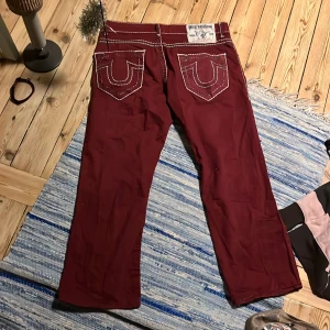 Vinröda byxor från True Religion - Snygga vinröda trueys som är unisex och Lågmidjade. 