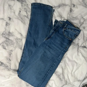 Blå jeans från Gina Tricot  -  Blå jeans med slits från Gina Tricot i modellen Molly. Midwaist. Använda fåtal gånger.