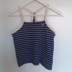 Lacoste top - Lacoste streckad top. Topen är vintage Lacoste (90-talet). Storlek 38.