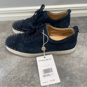Mörkblåa Loubs med vit sula - Säljer ett par snygga mörkblå sneakers från Christian Louboutin. Denna colorwayen är riktigt rare och eftersökt! Storlek 40.5 men passar lätt 41.5 eller större. Lapp från vestiaire collective vilket tyder på äktehet. Skriv för mer frågor!