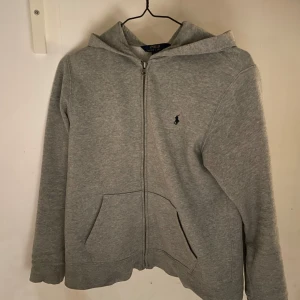 Ralph Lauren Zip-Hoodie - En grå Ralph Lauren Zip-Hoodie i toppskick! Storleken är i XS men passar även för mindre.