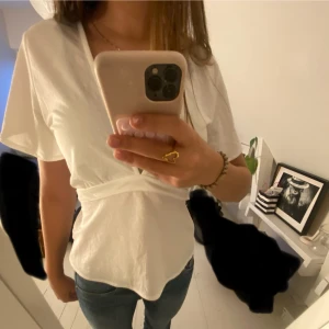 Vit top med rosett/ knut där bak💓 - En vit top från Gina som man kan knyta där bak lite urringad så därför använder jag inte så ofta. I bra skick har använt ca 2 gånger 🍂🤍finns inte kvar att beställa på ginas hemsida för den e slutsåld så säljer den för lite mindre än vad den kostar 