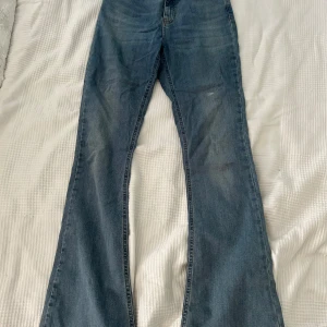 Blå jeans från Perfect Jeans - Säljer ett par snygga blå jeans från Ginatricot i storlek M. De har en klassisk bootcut-stil och är i ett välanvänt skick, finns några få fläckar (se bilder). 