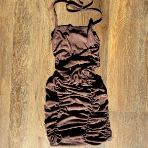 BRUN KORT KLÄNNING - Riktigt snygg och fint åtsittande klänning från Pretty Little thing! Aldrig kommit till användning tyvärr, nyskick!