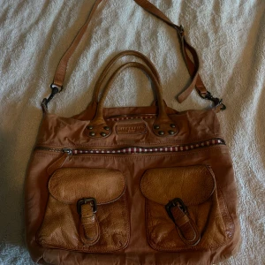 Väska - Säljer den här snygga vintage väskan som får plats med en mängd saker och är väldigt rymlig med två stora fack osen några små.