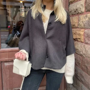 Svart kappa med knappar - Snygg svart/brun-  kappa/poncho med trekvartsärm och knappar framtill. Bilderna är lånade men samma jacka. 