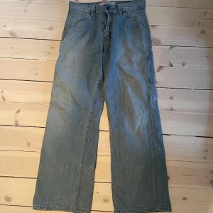 Blå Levis jeans - Blå jeans, finns ett litet hål på baksidan av ena benet samt små mini hål på andra benet. Inget man tänker på, annars bra skick!