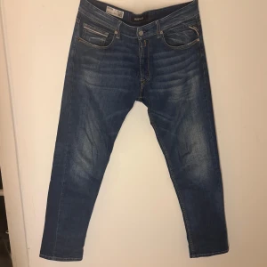 Blå jeans från Replay - Snygga blå jeans från Replay med klassisk femficksdesign och knappgylf. De har en lätt tvättad look och är perfekta för en avslappnad stil. Märkesdetaljer syns på bakfickan och linningen. Passar 175-185 centimeter toppen skick inga defekter sparsamt använda