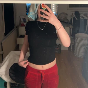 Svart kortärmad topp med öppen rygg - Säljer en stilren svart topp med korta ärmar och en djärv öppen rygg. Perfekt för en trendig look. Passar bra till både jeans och kjol.