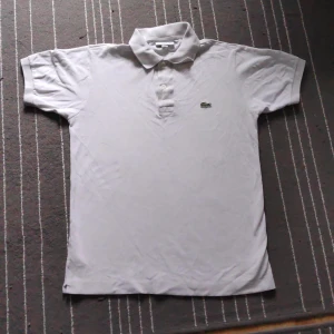 Lacoste piké - "PRIS KAN DISKUTERAS" Säljer min Lacoste piké som jag inte andvänder mer. Finns en defekt på bild 2 som jag sydde ihop. Inte säker om den är äkta. 
