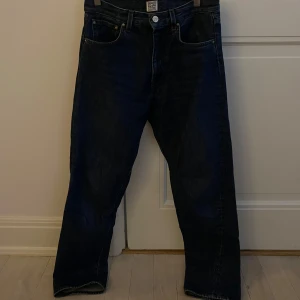 Mörkblåa jeansbyxor från Toteme  - Raka mörklblå Low-to-mid waist,  dvs medelhögmidjade jeans. Som går ner till ankeln. I storlek 25/32. Materialet är 100% återvunnen bomull.  Nypris 2400kr. Jeansen är i fint skick och sparsamt använda. 