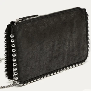 Svart axelväska med nitar - Snygg svart axelväska i mocka med coola silverfärgade nitar längs kanterna. Väskan har en dragkedja upptill och en kedja som axelrem. Nyckick och kan skicka mina egna bilder 💓