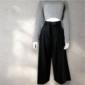 Zara-svarta vida byxor med knytband - Snygga svarta byxor från Zara med hög midja och knytband i midjan. Byxorna har en loose passform och vida ben, vilket ger en stilren och modern look. Perfekta för en chic och avslappnad stil.