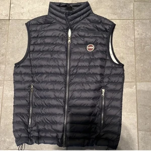 Colmar Väst - Snygg mörblå dunväst från Colmar. Västen har en quiltad design och en liten logotyp på bröstet. Perfekt nu för våren!🌼Passar dig med storlek s eller xs. Priset är självklart förhandlingsbart.