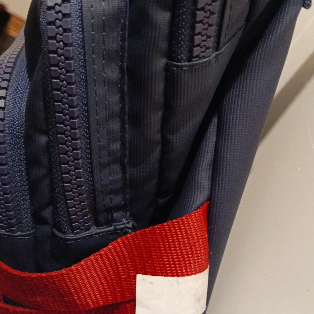 Säljer en snygg mörkblå axelväska från USPA Sport med flera praktiska fack och dragkedjor. Väskan har röda detaljer och en justerbar axelrem. Perfekt för att hålla ordning på dina saker när du är på språng. Använt 1 gång. Laukut & Käsilaukut.