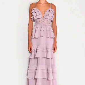 Ljuslila långklänning med volanger - Säljer en romantisk ljuslila balklänning med volanger och spetsdetaljer. Klänningen har en v-ringad design med smala axelband och flera lager av volanger. Köpt för 2150kr💘💘💘