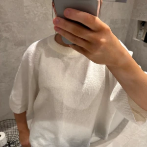 Vit tröja med trekvartsärm - Säljer en stilren vit tröja med trekvartsärm. Perfekt för en avslappnad look. Tröjan har en rund halsringning och är gjord i ett mjukt material.