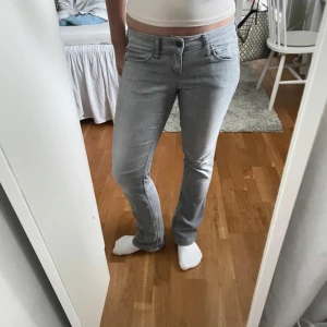 Grå jeansbyxor - Snygga grå jeansbyxor med en klassisk femficksdesign. De har en normal passform och är perfekta för en avslappnad stil. Byxorna har en knapp och dragkedja framtill.