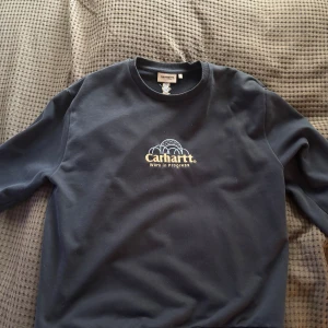 Mörkblå sweatshirt från Carhartt - Tröja från carhartt säljes i storlek L passar även dig med storleken M. Köparen står för frakten. 