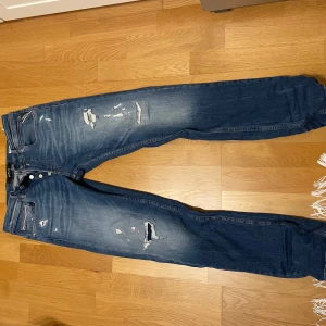 Blå jeansbyxor från Replay - Snygga blå jeansbyxor från Replay i modellen Grover med straight fit. 30 W, 32 L. Nice slitning och knappar i midjan. Grymt skick, endast använda fåtal gånger. Kom med bud, och ställ frågor.