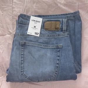Blå bootcut jeans från 157 - Säljer ett par blå lågmidjade bootcut jeans från 157. De är helt nya med prislappen på, aldrig använda