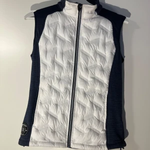 Vit och marinblå väst från dormy  - Snygg vit och marinblå väst från Abacus med dragkedja framtill. Köpt på golfbutiken dormy. En kvinnlig golfväst. Knappt använd 