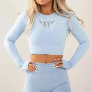 Ljusblå croppad tröja från Divina🩵 - Snygg ljusblå croppad tröja från Divina med långärmad design och ett coolt hålmönster framtill. Tröjan har en öppen ryggdetalj som ger en extra touch. Skriv till mig ifall du vill köpa med tightsen också, dom har tyvärr ett litet hål längre ner på byxan, som jag nu har sytt igen så gott jag kunde. (Syns knappt) Dom kommer jag sälja väldigt billigt om man köper tröjan!🩵Bara att fråga om bild på hålet med lagningen om du är intresserad!!