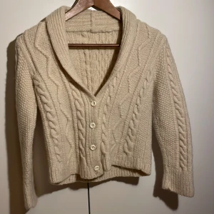  Beige handgjord cable knit kofta i ull (dam) - Koftan är köpt second hand men är aldrig använd, den är i bra skick men den saknar en knapp vilket inte syns. Den är ganska liten i storleken. ‼️pris kan diskuteras‼️