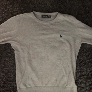 Grå tröja från Polo Ralph Lauren - Säljer en stilren grå tröja från Polo Ralph Lauren med rund halsringning.. Endast använd fåtal gånger. Storlek är m men passar s också. 