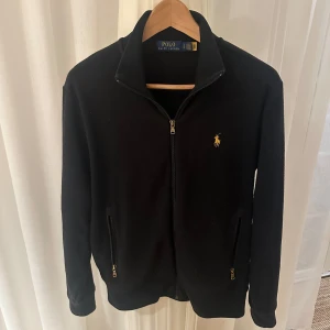 Polo Ralph Lauren fleece - Säljer denna Polo Ralph Lauren fleecen i en snygg svart färg. Bra skick och nypris ligger runt ca 2000 kr. Storlek S men sitter snäppet större kanske. Hör av dig vid minsta lilla fråga😄🤝
