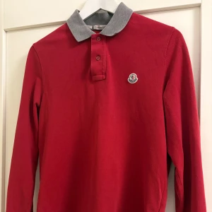  Moncler Piké röd - Snygg röd pikétröja från Moncler, modell slim fit.  Skick 7/10. (Äkta)