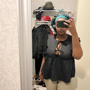 Svart blus med knytning - Jättefin svart blus med knytning framtill och trekvartsärmar som tyvärr inte kommit till användning. Storlek L