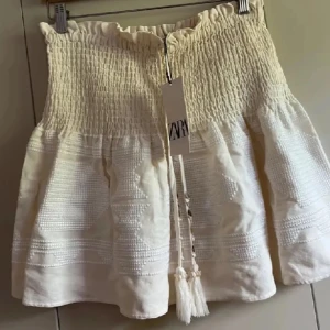 Sååå fin Vit kjol från Zara (passar xs-m)❤️❤️🥹 - Säljer en söt vit kjol från Zara. Helt ny då den inte kommit till användning. Passar mig som vanligtvis har xs, då den är stretchig. 🥰Perfekt för varma dagar!