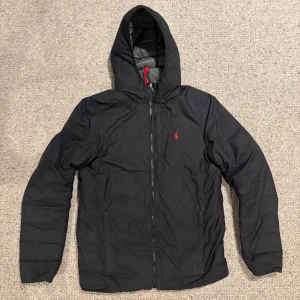 Svart dunjacka från Polo Ralph Lauren - Säljer en svart dunjacka från Ralph Lauren med huva. Skulle säga att den passar bäst för tidig vår, sen vinter eller höst. Jackan är i storlek xs men lite stor i storleken och skulle säga att om man är runt 170 passar den perfekt. Den är i bra skick då inget är trasigt och den ser bra ut. 