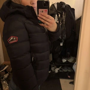 Svart superdry dunjacka - Säljer en svart dunjacka från Superdry. Super snygg jacka som aldrig kommit till användning, prislapp finns även kvar på jackan! Den kostar 2300 nypris☺️pris går att diskutera!
