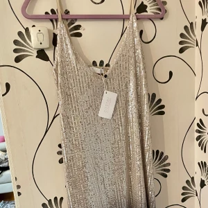 Coster Copenhagen 38/42 - Ny vacker paljettklänning i silver/blått. Storlek 40 men passar M/L. Nypris 1299:- prislapp kvar