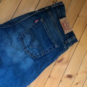 Blå jeans från Levi's - Säljer ett par klassiska blå Levi's jeans med en snygg tvätt och femficksdesign. De har en bekväm passform och är perfekta för en avslappnad stil. Levi's logga syns tydligt på bakfickan. W32 L34