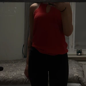 Röd ärmlös topp från Only - Snygg röd ärmlös topp från Only med smala axelband och en liten öppning framtill och bak. Perfekt längd. Toppen är i ett mjukt och bekvämt material.